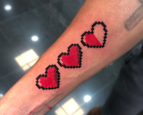 Tatuaje de 3 corazones rojos en pixeles