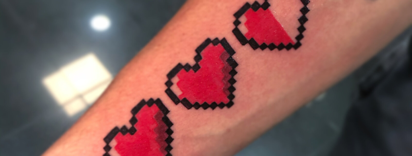 Tatuaje de 3 corazones rojos en pixeles