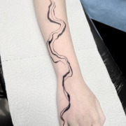 Tatuaje abstracto de lineas y ondas en el antebrazo y en la mano