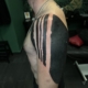 Tatuaje en el hombro de un hombre de lineas gordas negras.