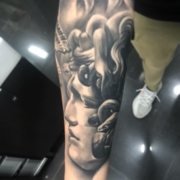 Tatuaje de la escultura de la diosa griega Medusa en realismo en negro y grises