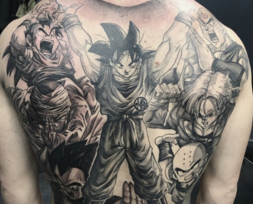 Espalda de un hombre tatuada al completo con una composicion de personajes de la serie Dragon Ball.
