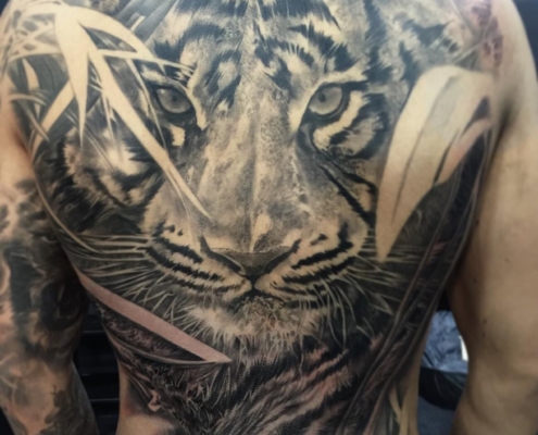 Tatuaje en la espalda de un hombre de un tigre realista.