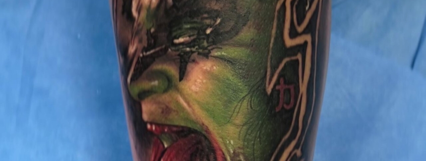 Tatuaje realista en el muslo de un hombre de Gene Simmons de la banda Kiss.