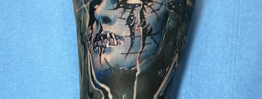 Tatuaje a color de Joey Jordison, el bateria de la banda Slipknot en el gemelo de una mujer.